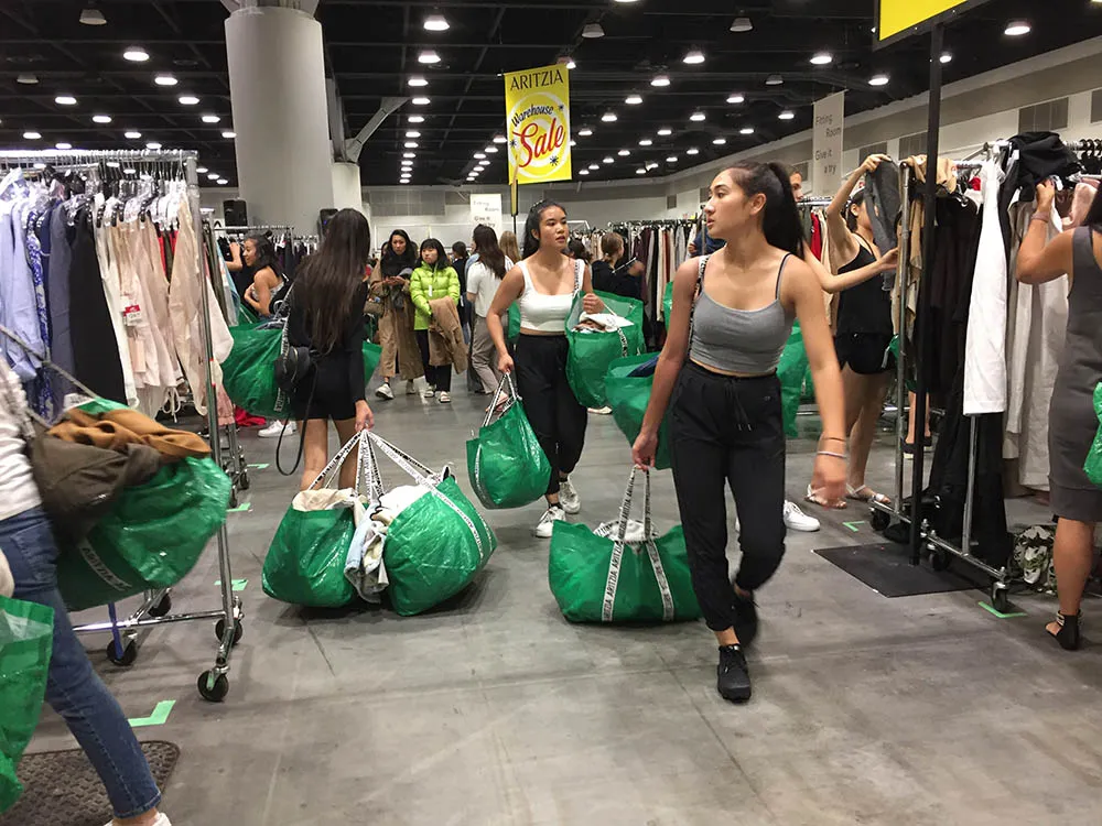 Shoppers eagerly scanning the racks for must-have items at the Aritzia Warehouse Sale.